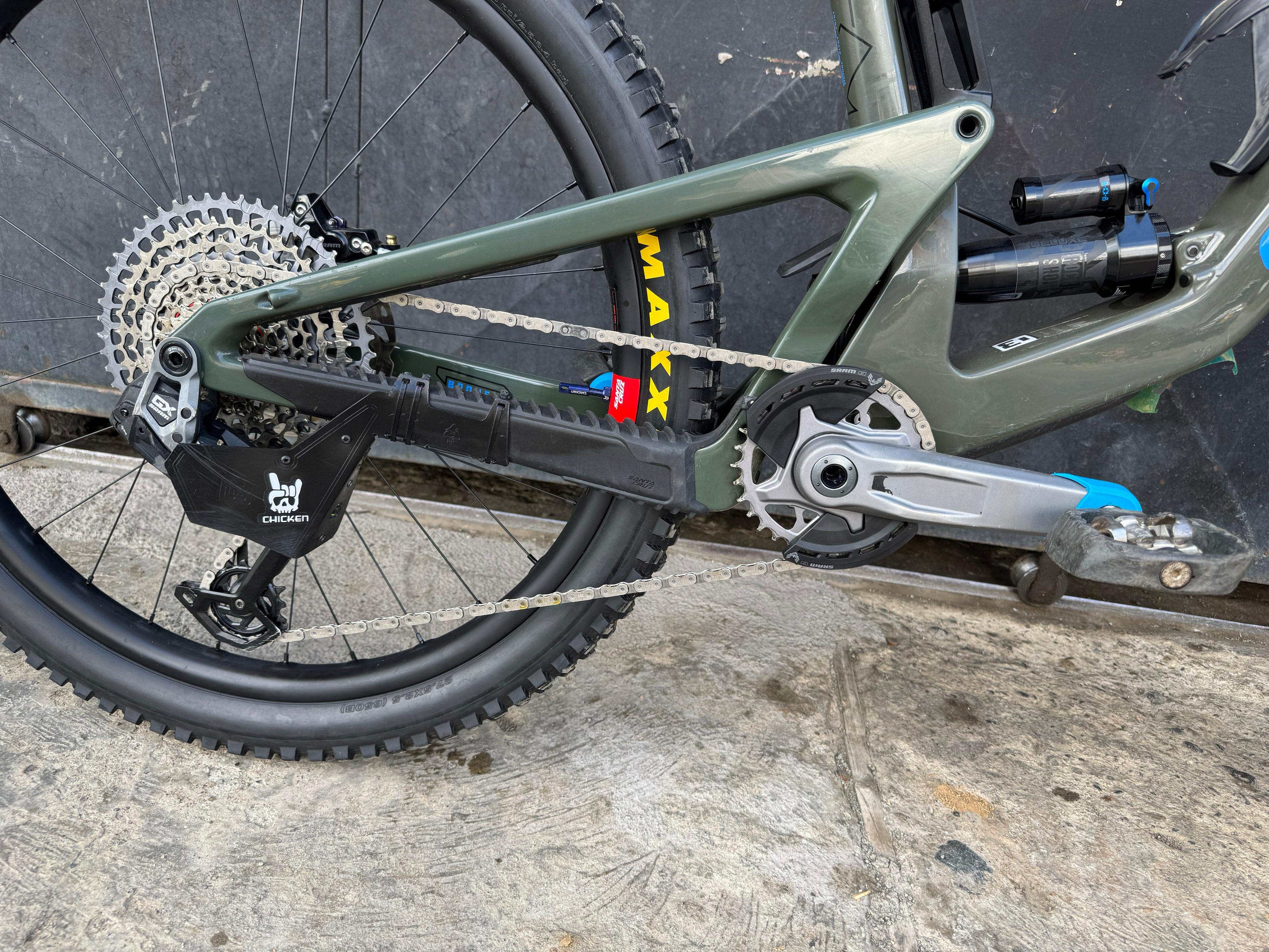 Detalle de transmisión, biela y suspensión de la bicicleta demo Santa Cruz Bronson verde.