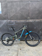 Bicicleta demo Santa Cruz Bronson verde oliva vista de lado en formato vertical.