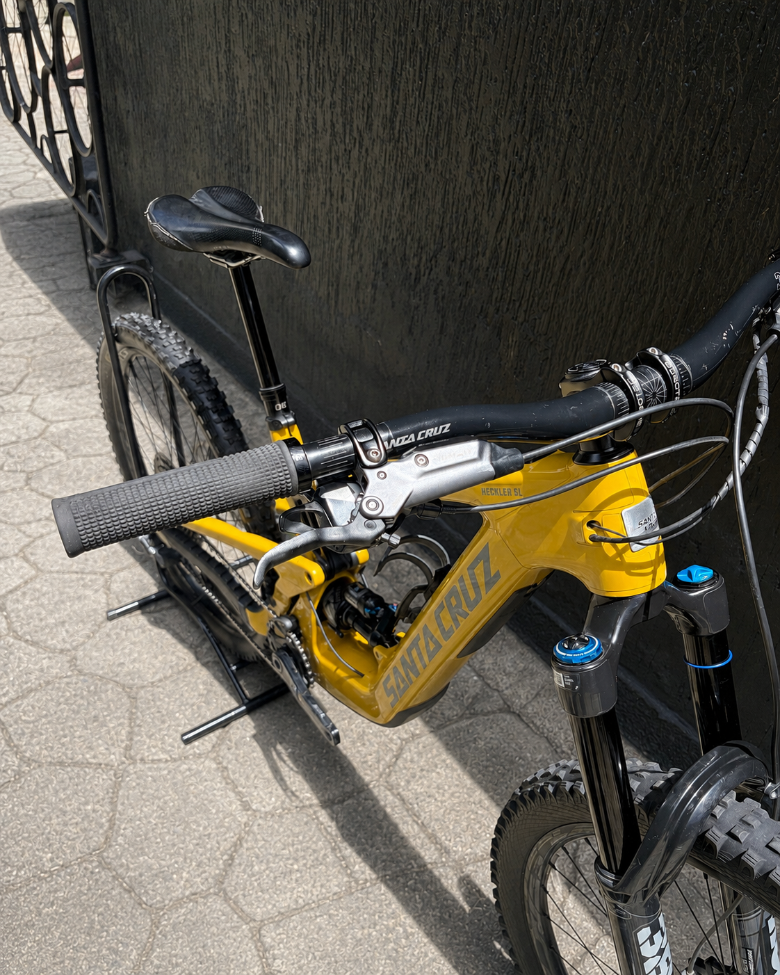 Detalle del manubrio, frenos y parte frontal de la bicicleta demo Santa Cruz Heckler SL amarilla.