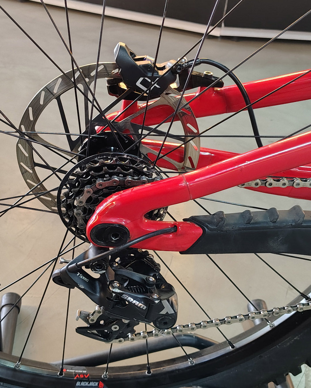 Detalle de la transmisión SRAM y freno trasero de la bicicleta demo Santa Cruz V10.8 Kit X0 roja.