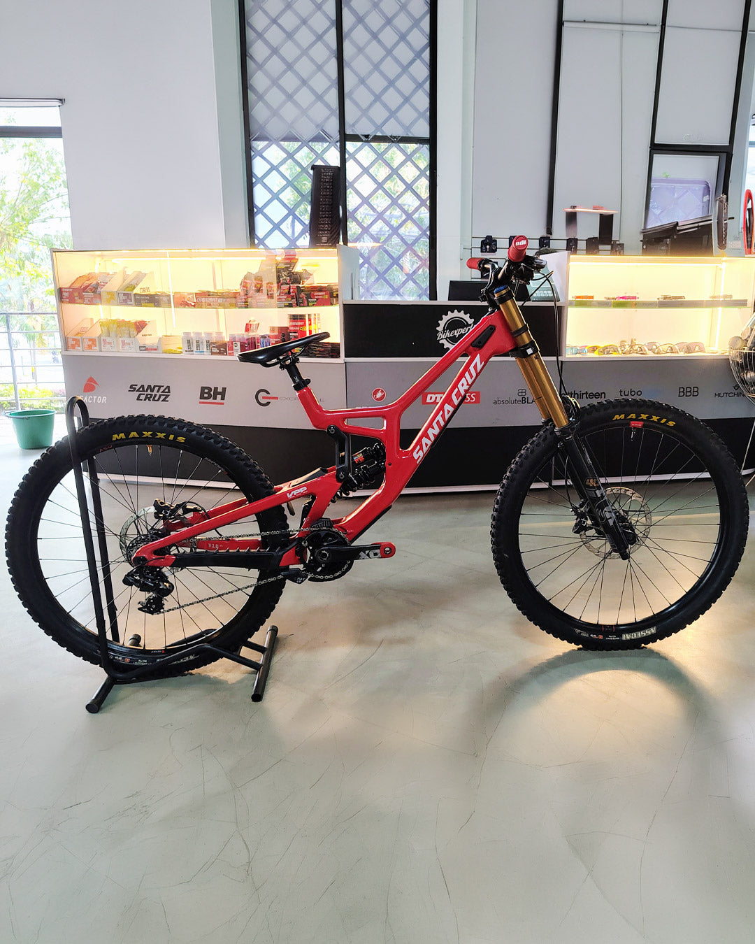 Bicicleta demo Santa Cruz V10.8 Kit X0 roja vista lateral sobre soporte en Bikexperts.