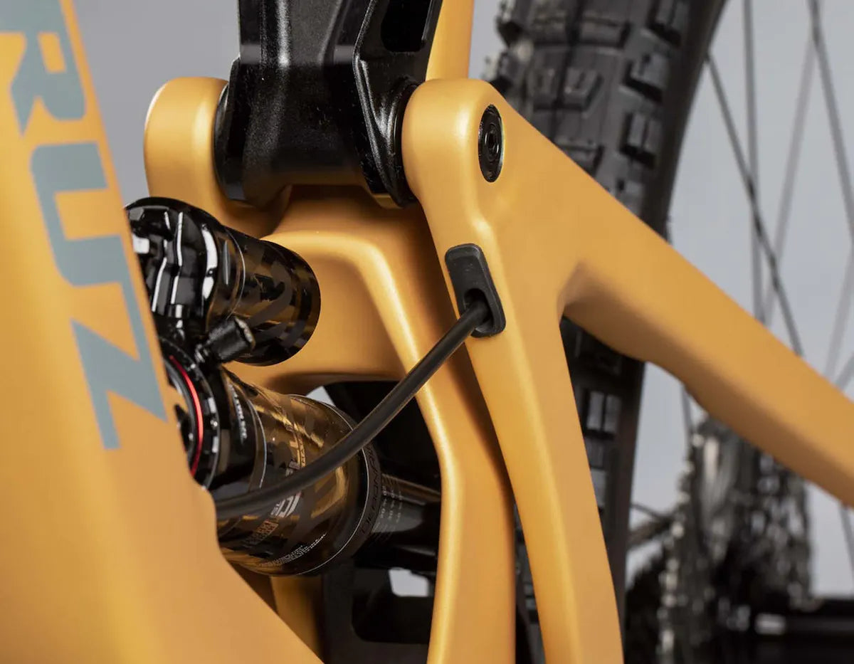 Detalle del amortiguador trasero y pivote del cuadro dorado Santa Cruz Bronson.