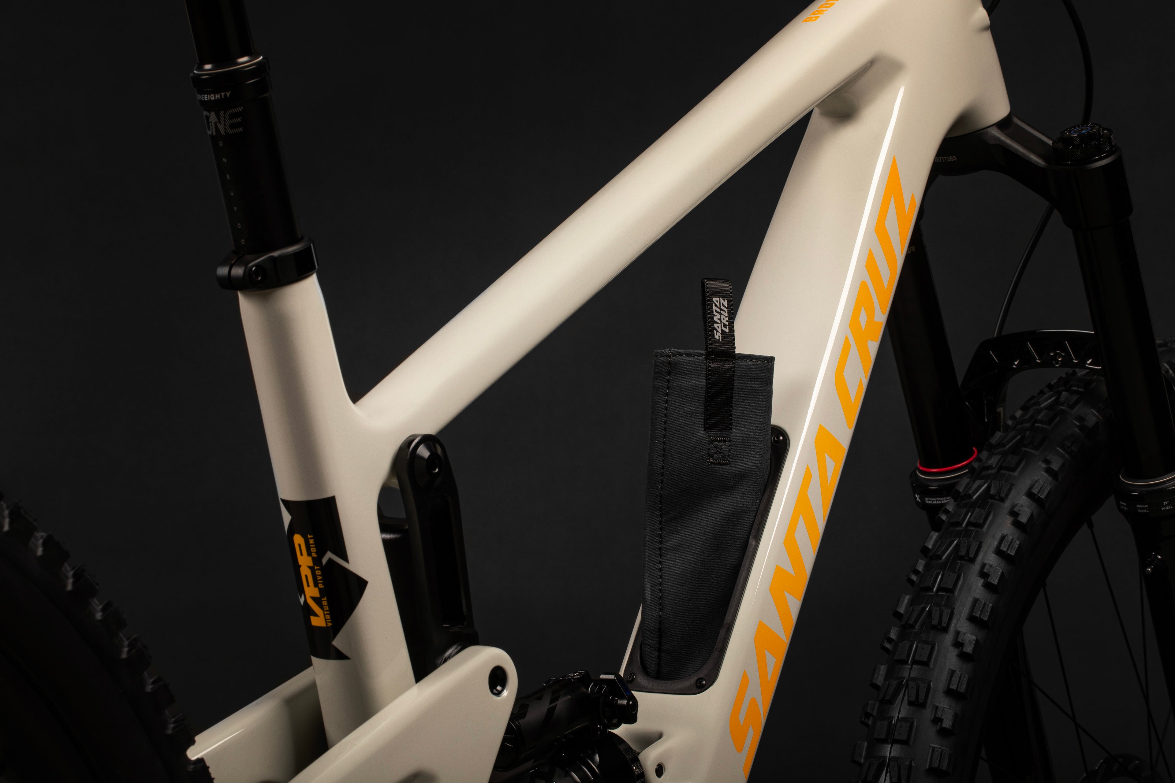 Detalle de bolsa instalada en el tubo diagonal blanco de la bicicleta Santa Cruz Bronson V4.