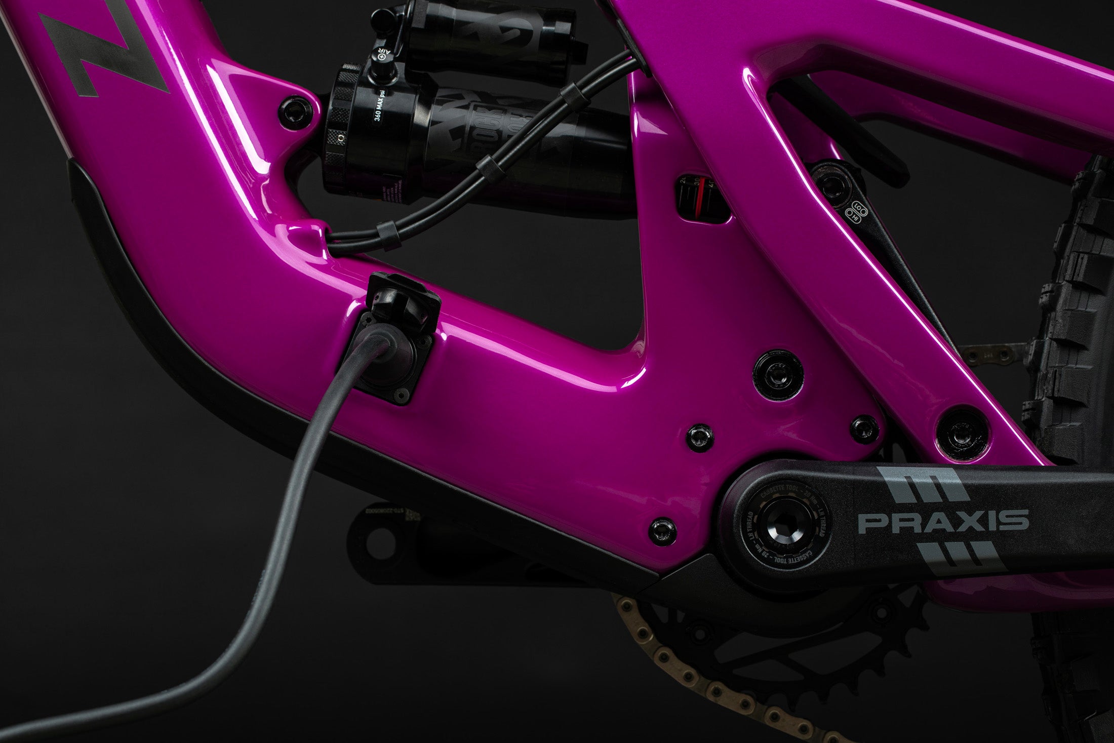 Detalle del puerto de carga conectado en la Santa Cruz Heckler SL C Kit Stout magenta.