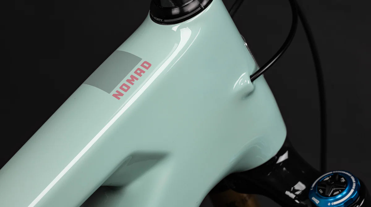 Detalle del tubo superior verde menta con nombre Nomad en la bicicleta Santa Cruz Nomad V6.