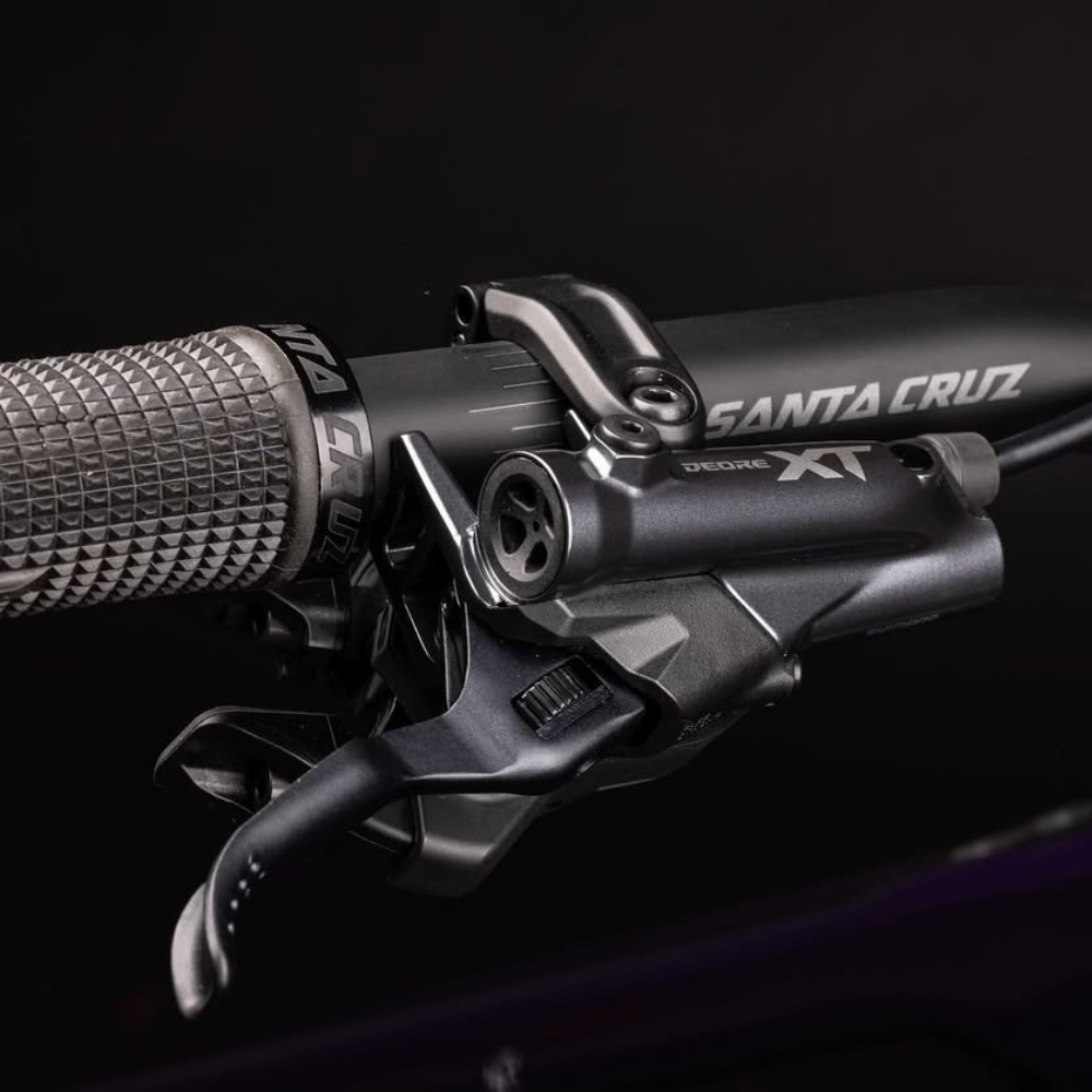 Detalle del mando Shimano Deore XT Di2 en el manubrio de la Santa Cruz Vala C MX morada.
