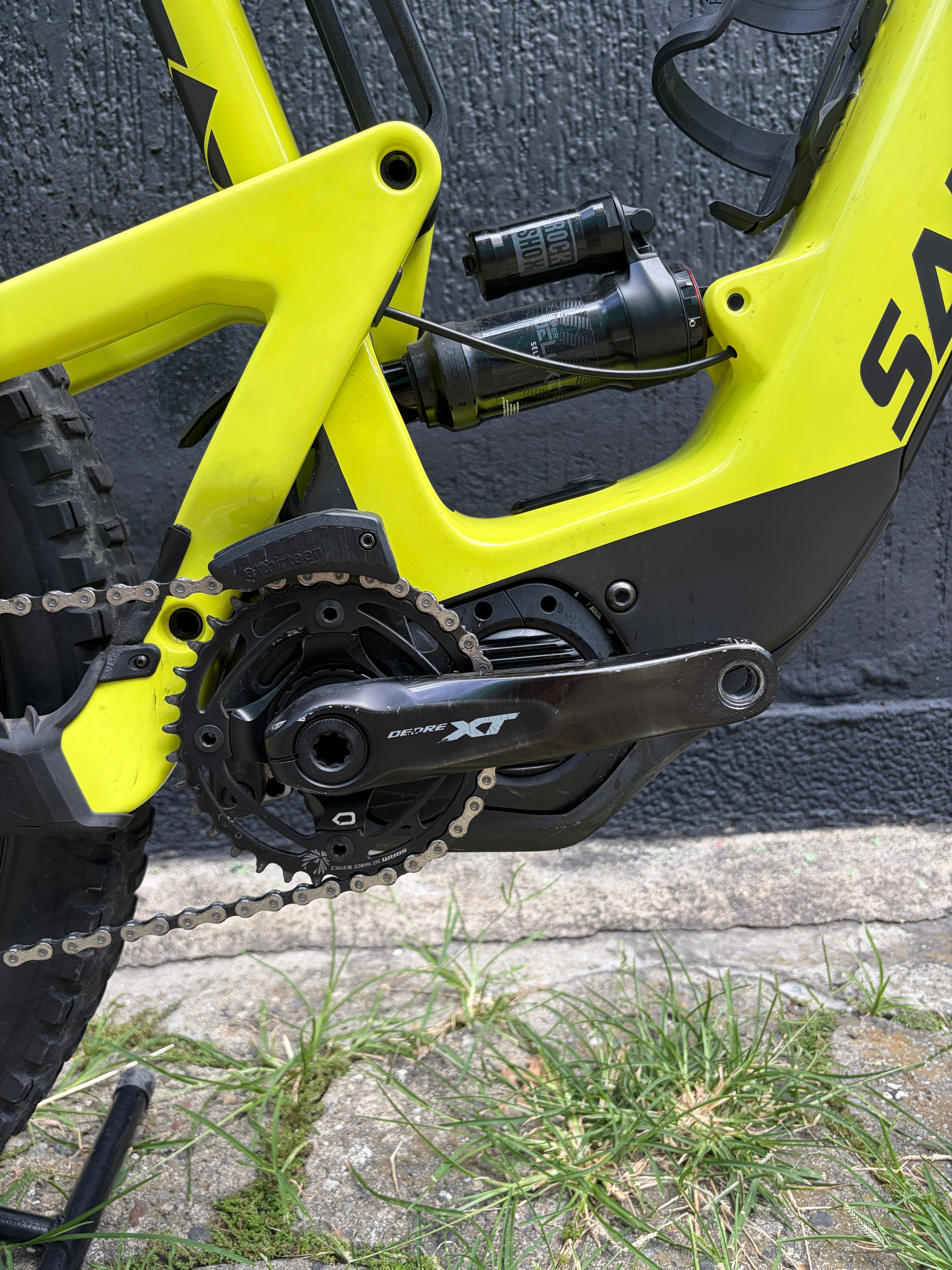 Detalle del motor, biela y amortiguador de la bicicleta usada Santa Cruz Heckler 8 verde lima.