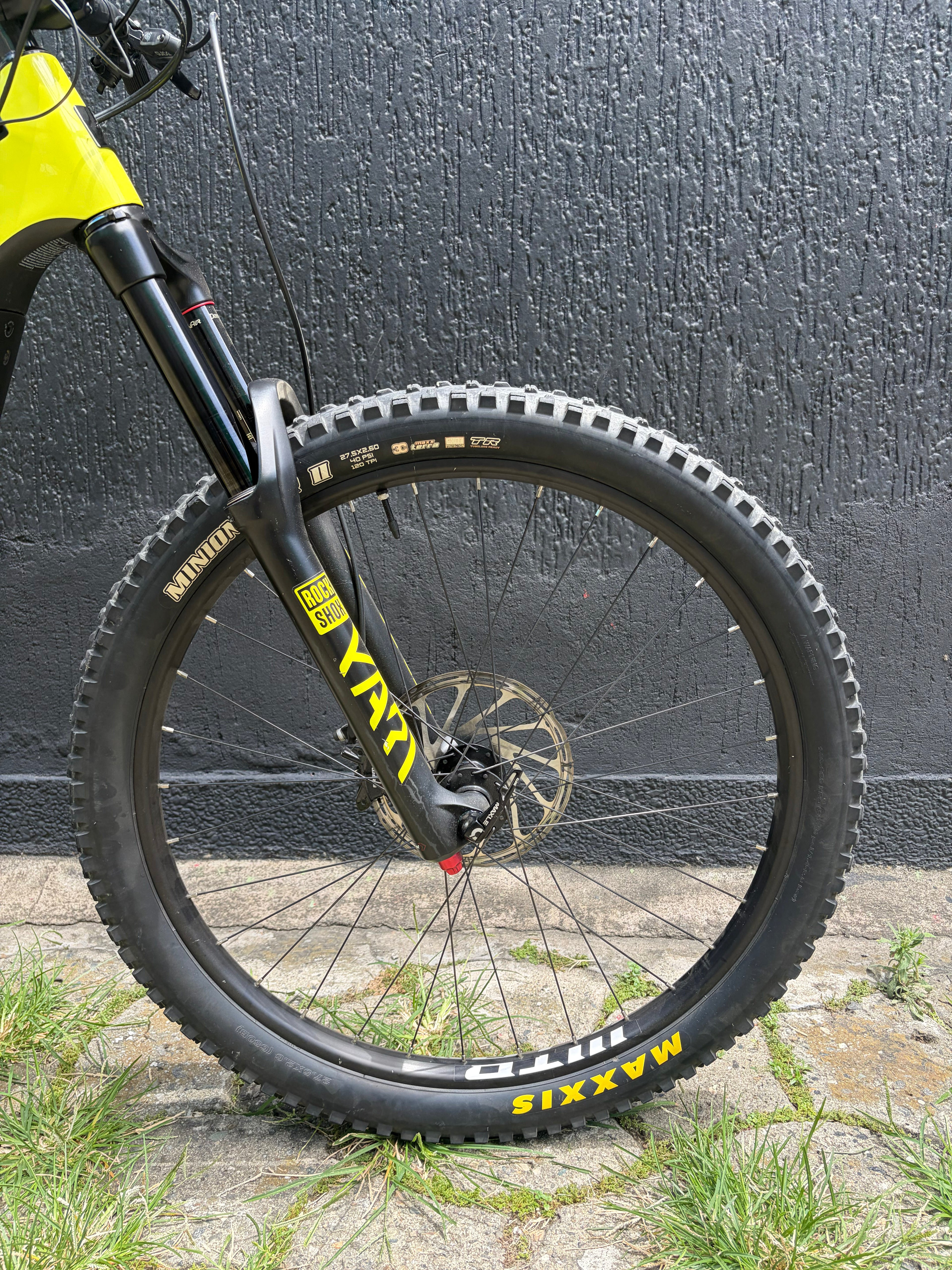 Detalle de la rueda, horquilla y freno delantero de la Santa Cruz Heckler 8 usada verde lima.