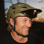 Ciclista usando casco Smith Forefront 3 Matte Forest con gafas almacenadas bajo la visera