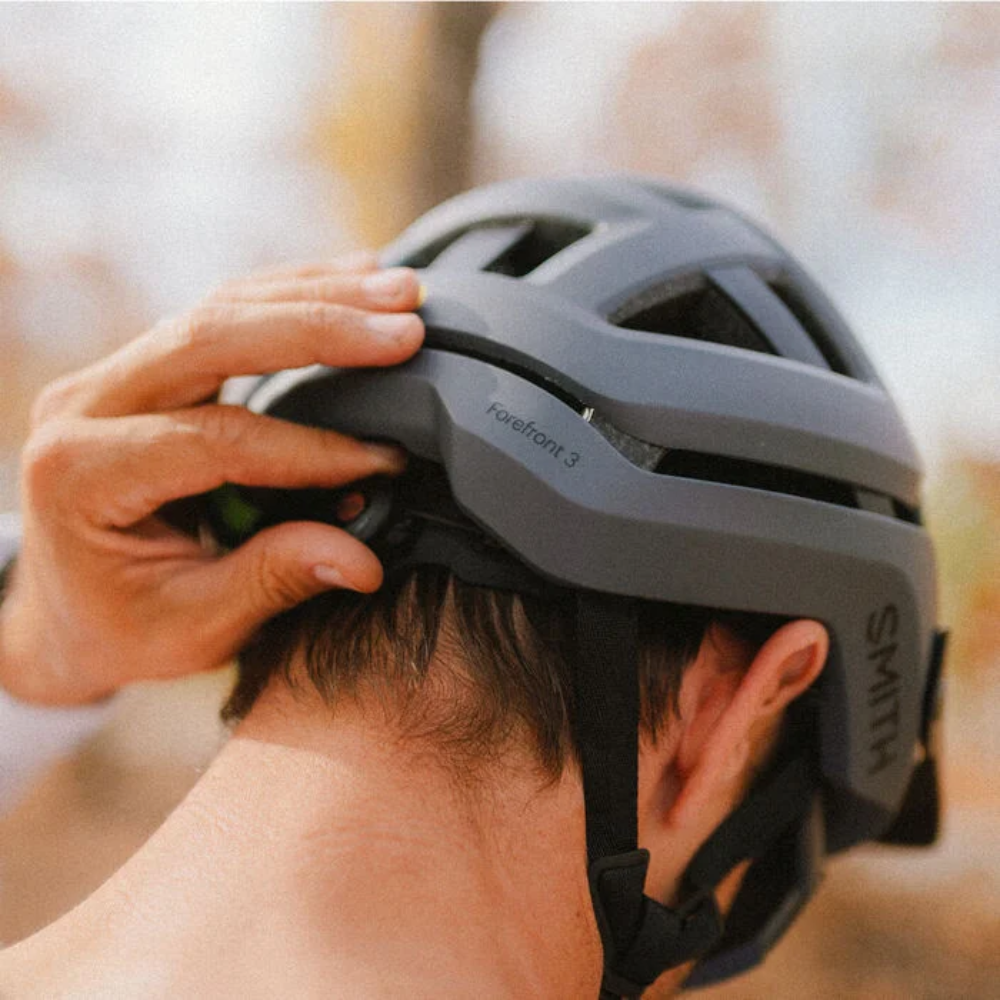 Ciclista ajustando el sistema BOA del casco Smith Forefront 3 Matte Slate, vista posterior en primer plano
