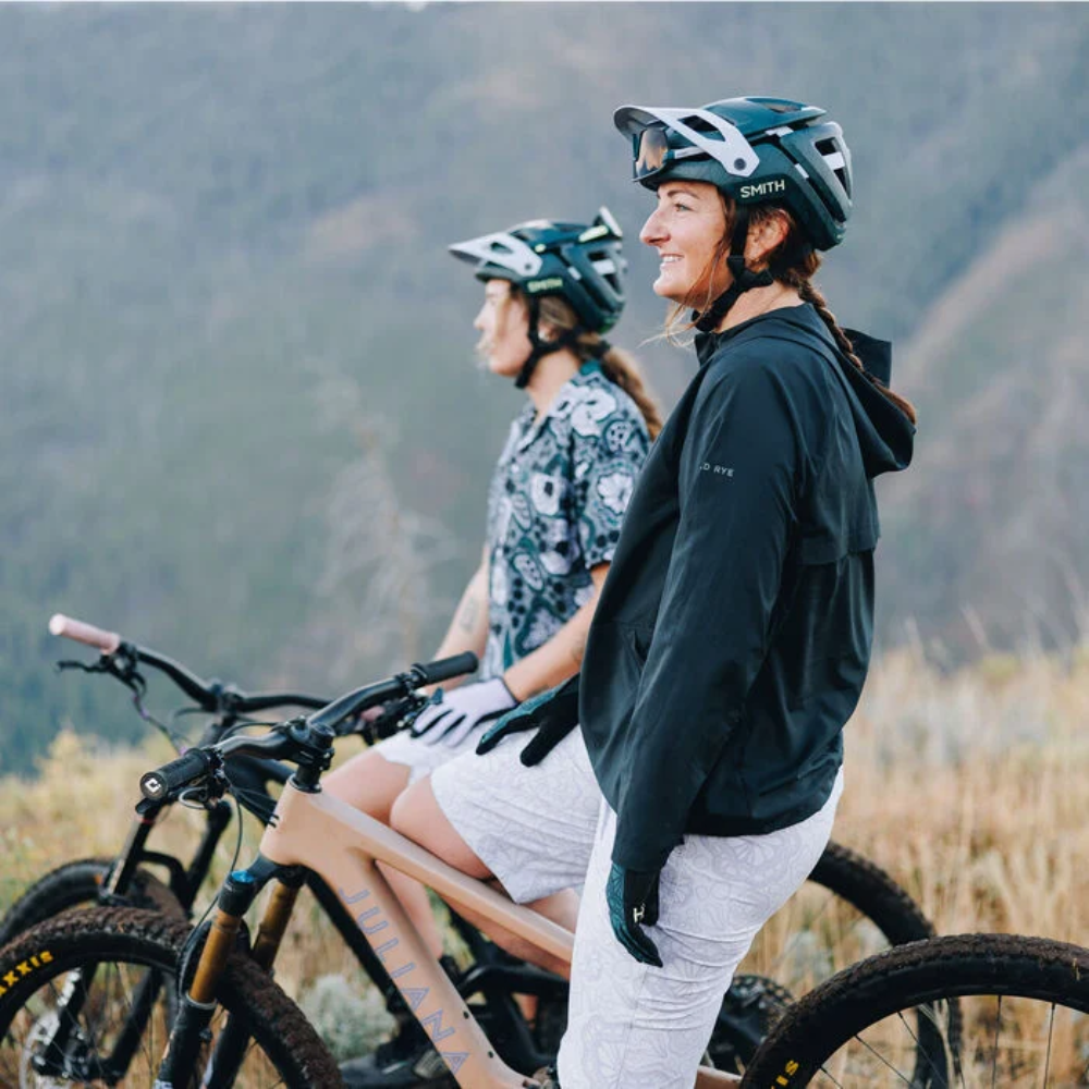 Dos ciclistas usando cascos Smith Forefront 3 edición Smith x Wild Rye junto a sus bicicletas de montaña