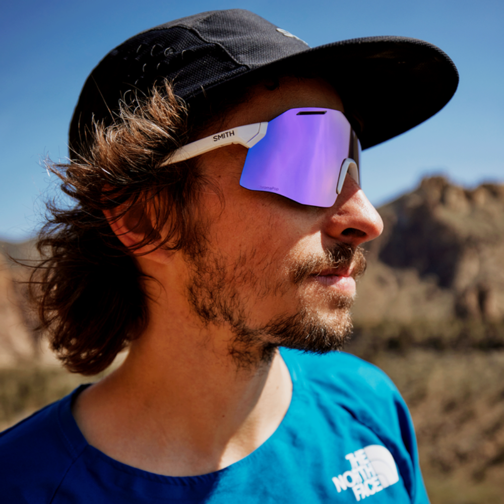 Corredor usando gafas Smith Vert Running blancas con lente violeta espejo ChromaPop, vista lateral en primer plano