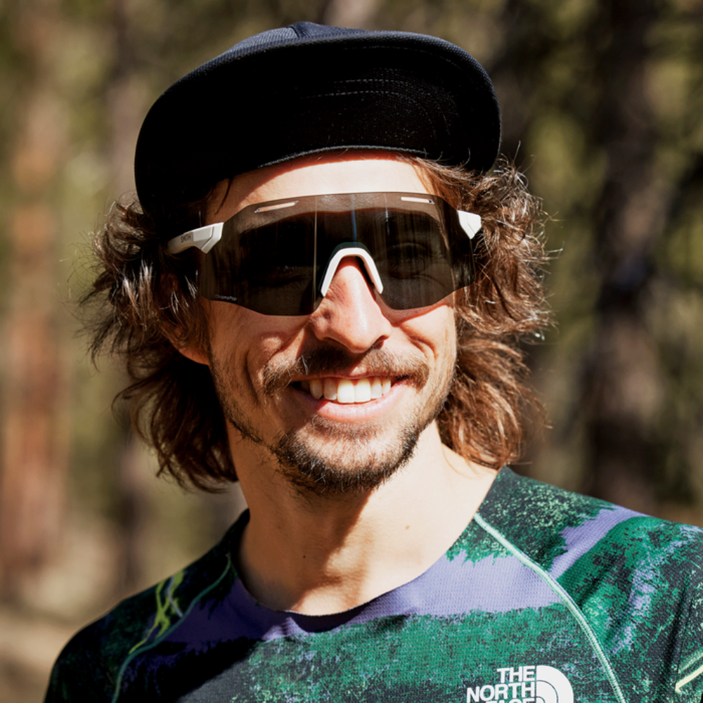Corredor usando gafas Smith Vert Running Matte Bone con lente negra espejo ChromaPop, retrato frontal al aire libre